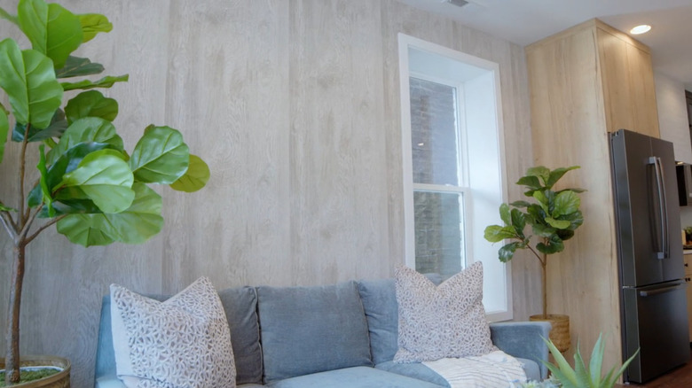 A living room with a textured wallpaper accent wall