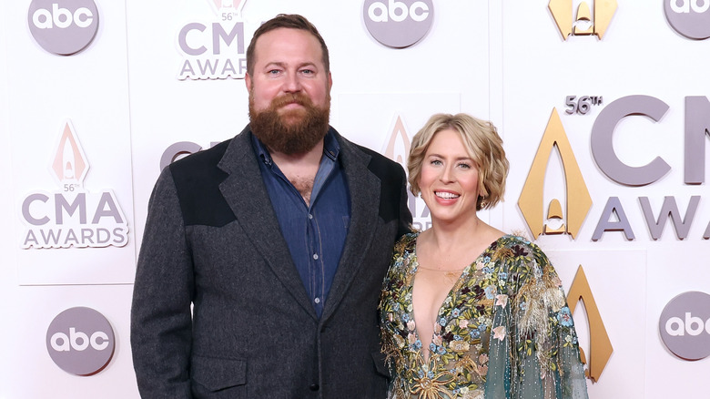 Ben and Erin Napier pose in front of red carpet background