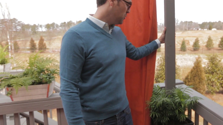 Man pointing to planter box with pole