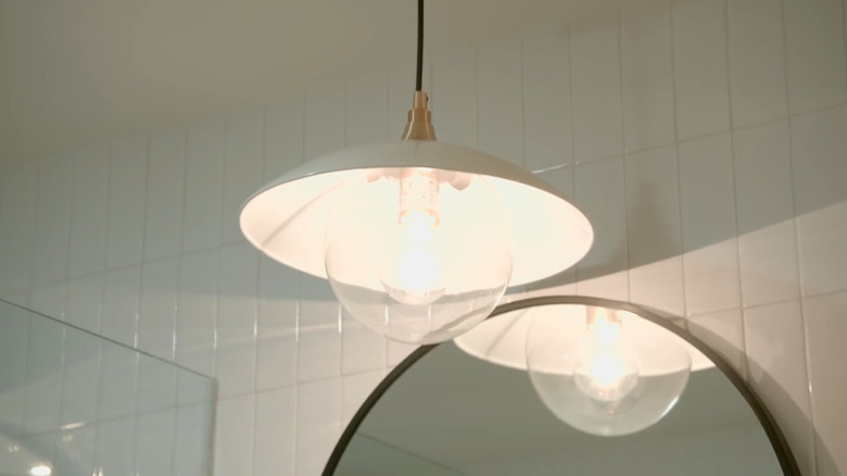 A pendant light over a bathroom mirror