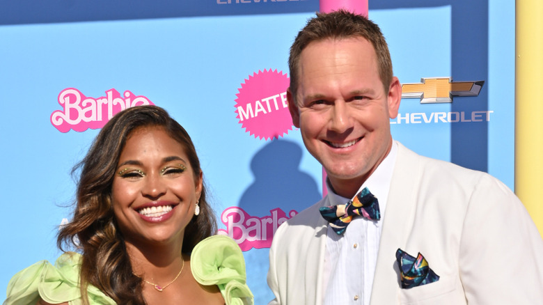 Mika Kleinschmidt and Brian Kleinschmidt smile together on the pink carpet for HGTV's Barbie home renovation