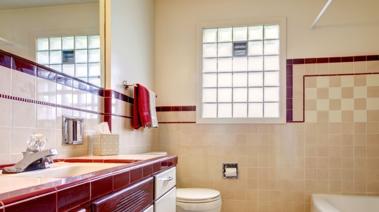 beige bathroom with outdated glass block window