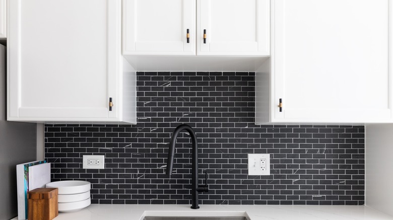 white cabinets with black subway tile