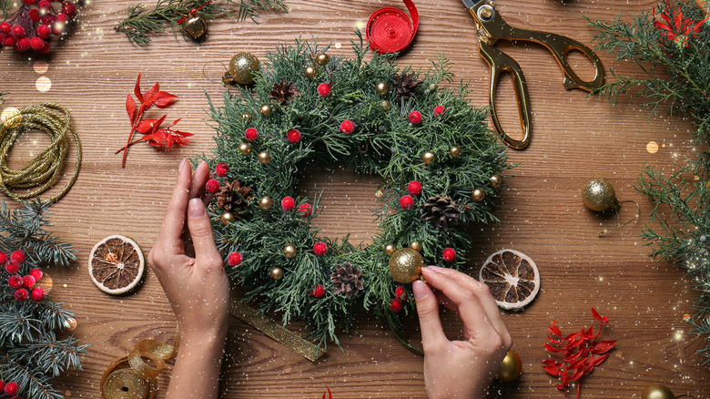 Hands decorating Christmas wreath