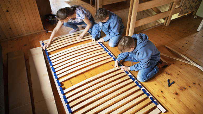 kids and mom assembling bed