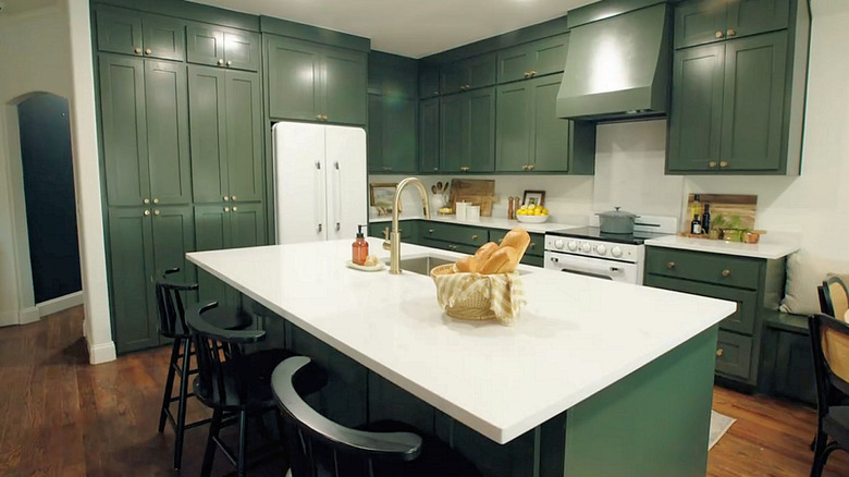 newly renovated green kitchen with white counters and appliances