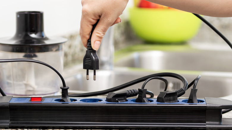 woman uses kitchen power strip