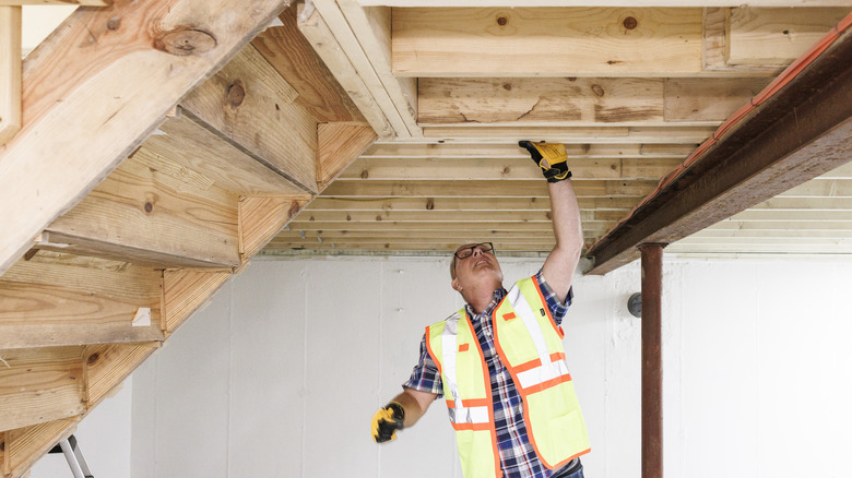 man working under stairs