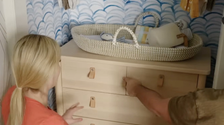 Jasmine Roth places a wood dresser into a closet alcove