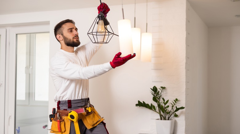 man installing lights in kitchen