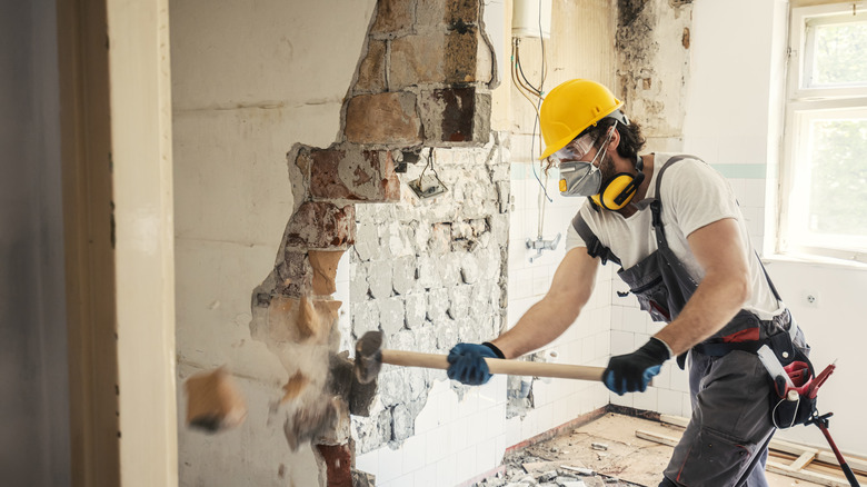 man demoing a wall