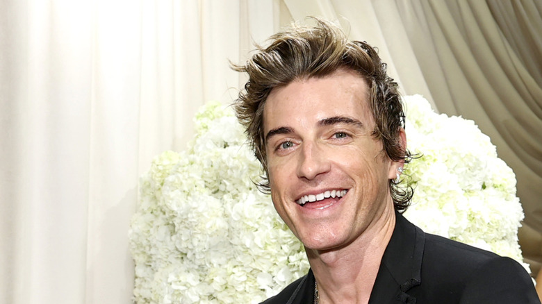 Jeremiah Brent posing for a photo in front of a white backdrop.