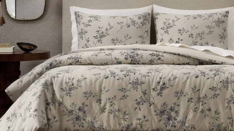 A floral print duvet comforter set, in the shade "Beige" displayed on a bed