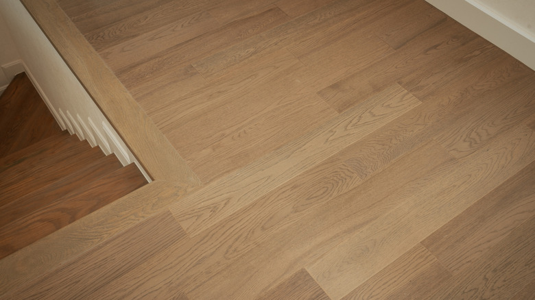 An engineered wood floor leading up to the staircase