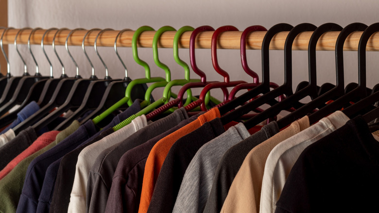 Sets of different-colored hangers in a closet