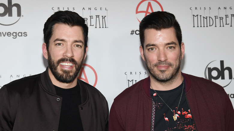 The Property Brothers Drew and Jonathan Scott standing and posing for the cameras