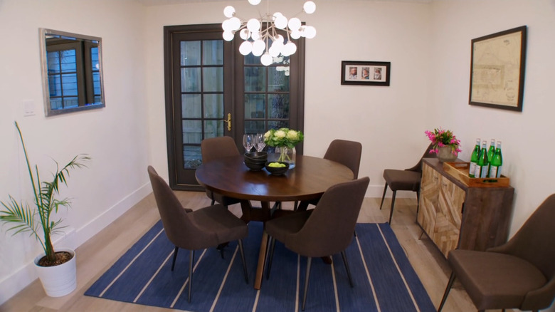 A dining room with a round table and French doors.