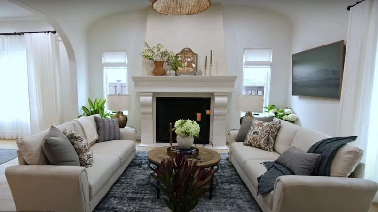 A white living room with a large fireplace.