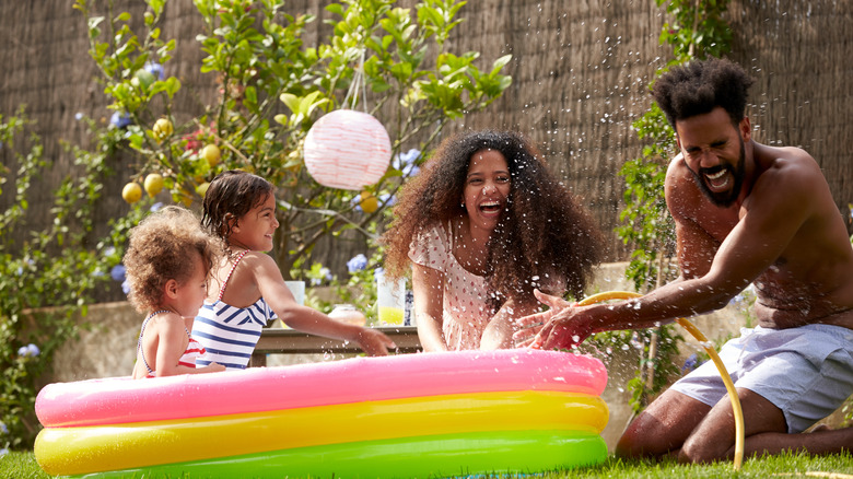 family playing in pool