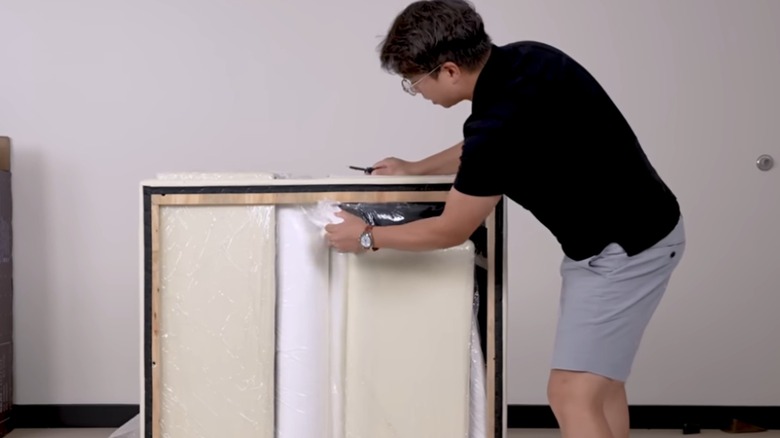 man unboxing couch-in-a-box