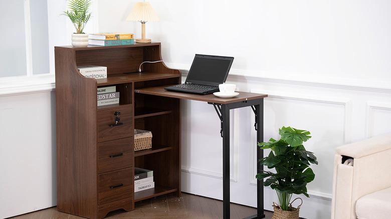 Laptop sitting on fold-out desk in walnut brown finish