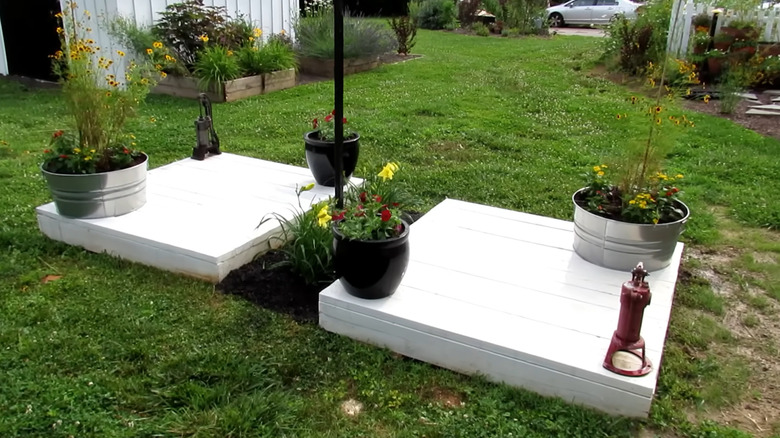 plants in containers on a deck over a septic tank lid