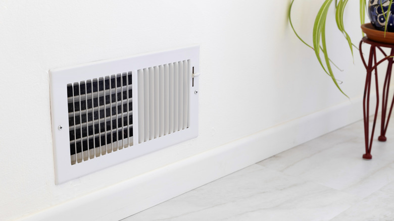 Standard wall vent in home interior with white walls