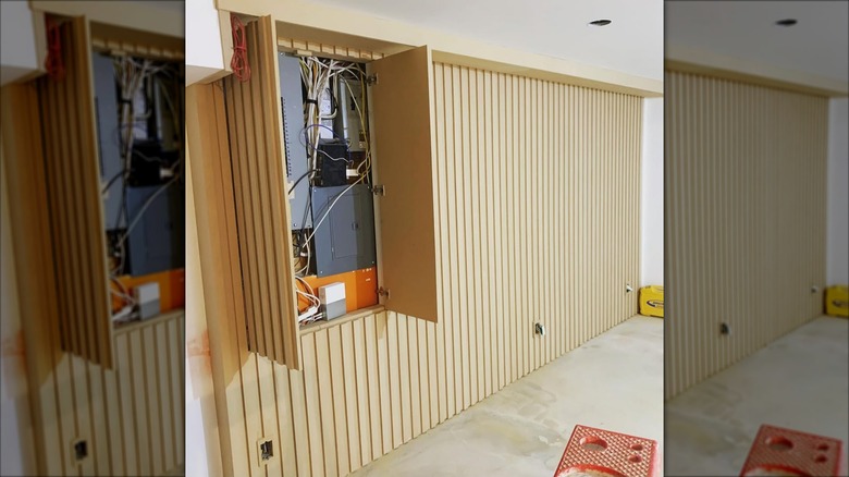 a slatted wall with cutout for electrical panel