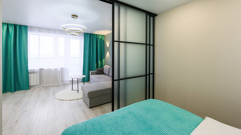 Interior of bedroom with glass sliding doors between bedroom and living room