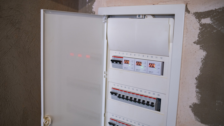 Opened breaker box with a metal door