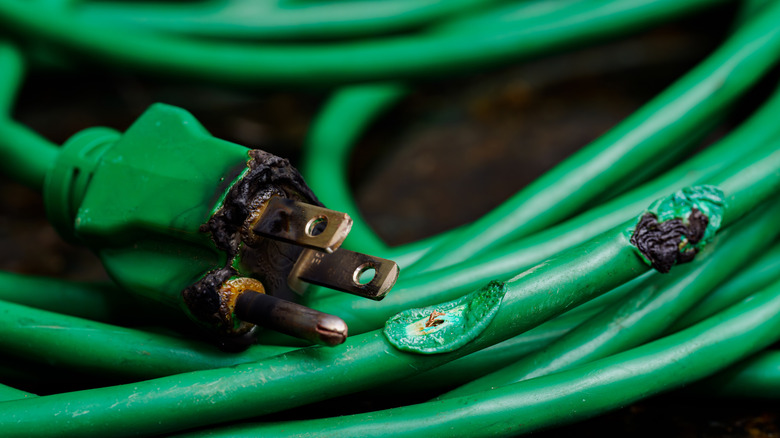 A green extension cord that has melted