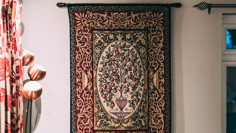 A tapestry hung on a wall from a curtain rod