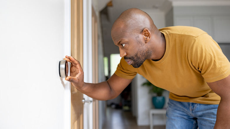 Person adjusting the thermostat