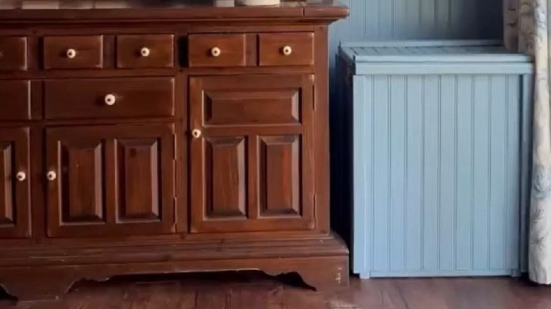 Trash can enclosure painted blue to blend into wall