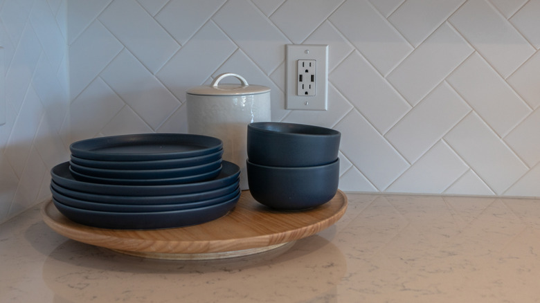 Plates and cups in front of a kitchen outlet
