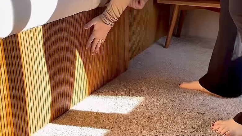Woman reattaching pole wrap to a bed frame