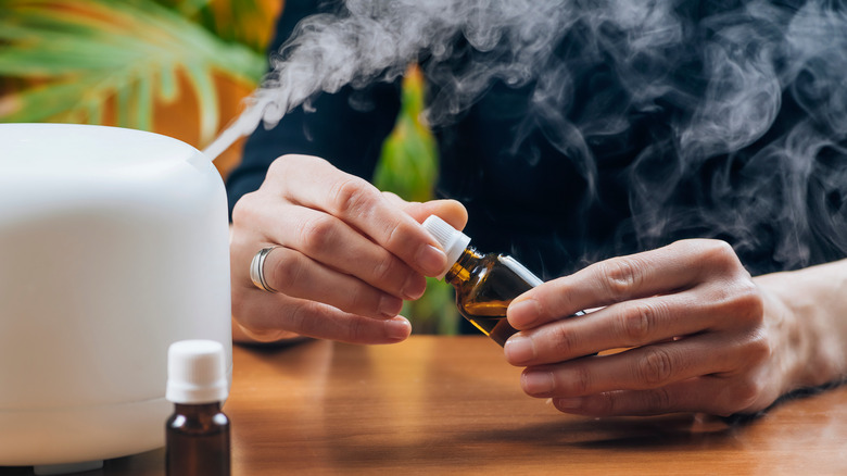 woman opens diffuser oil bottle