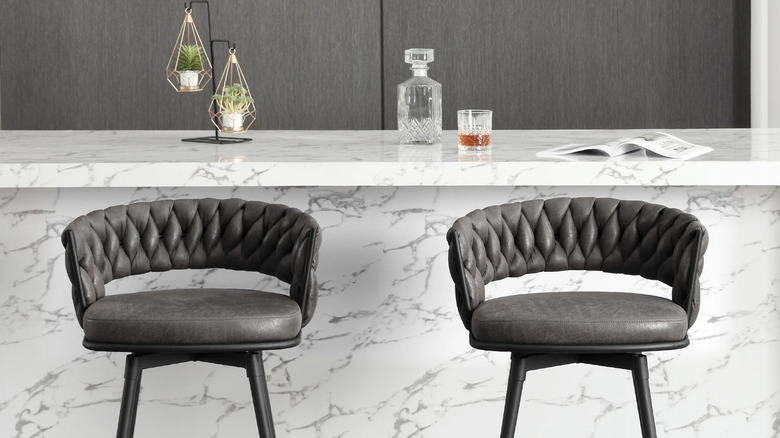 Medium-height bar stools styled near a marble countertop from Wayfair