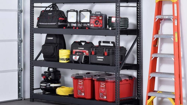 Close-up of person loading a HDX tote box onto a HDX shelving unit
