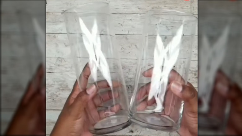 Hands holding two Dollar Tree cylinder vases