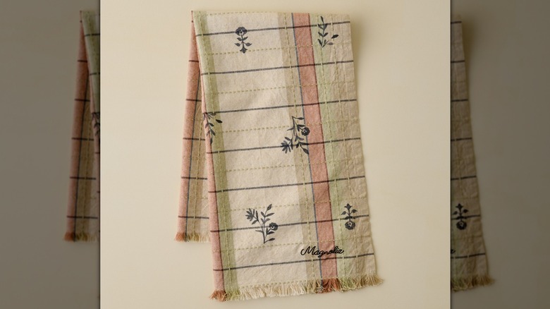 Plaid green and pink kitchen towel with black floral designs