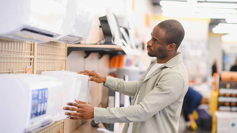 A man assessing different AC models at the store