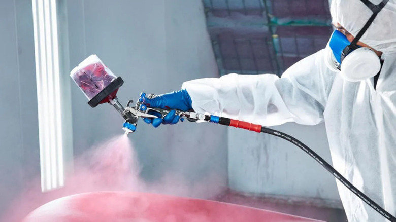 A man using Spectrum's Premium HTE Gravity-Feed Air Spray Gun with Side Fan Control, 1.3mm Nozzle