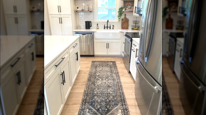 Stylish vintage neutral beige, gray, and blue rug in a contemporary kitchen with white cabinets and countertops