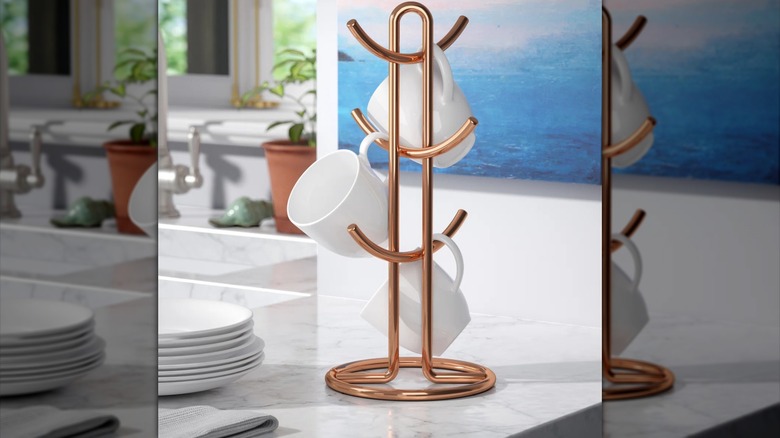Kitchen countertop copper mug holder on white stone counter