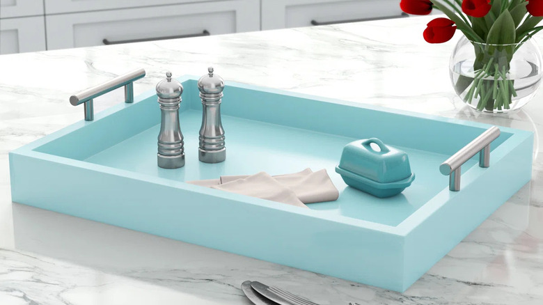 Light blue kitchen tray on white stone counter with metal pepper shakers