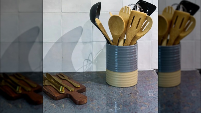 Blue gray and beige cooking utensil holder fully stocked on unique blue stone countertop