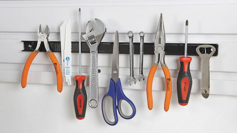 Tools hang on a magnetic tool holder.