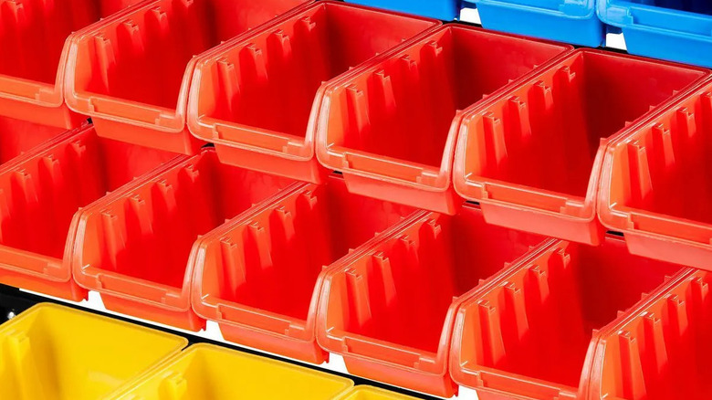 Colorful bins hang are lined up on a rack.