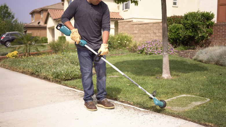 A person using Makita's 18V LXT Lithium-Ion Brushless Cordless String Trimmer